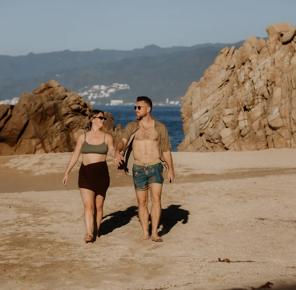 Pareja caminando por la playa alrededor de Xinalani en Verano