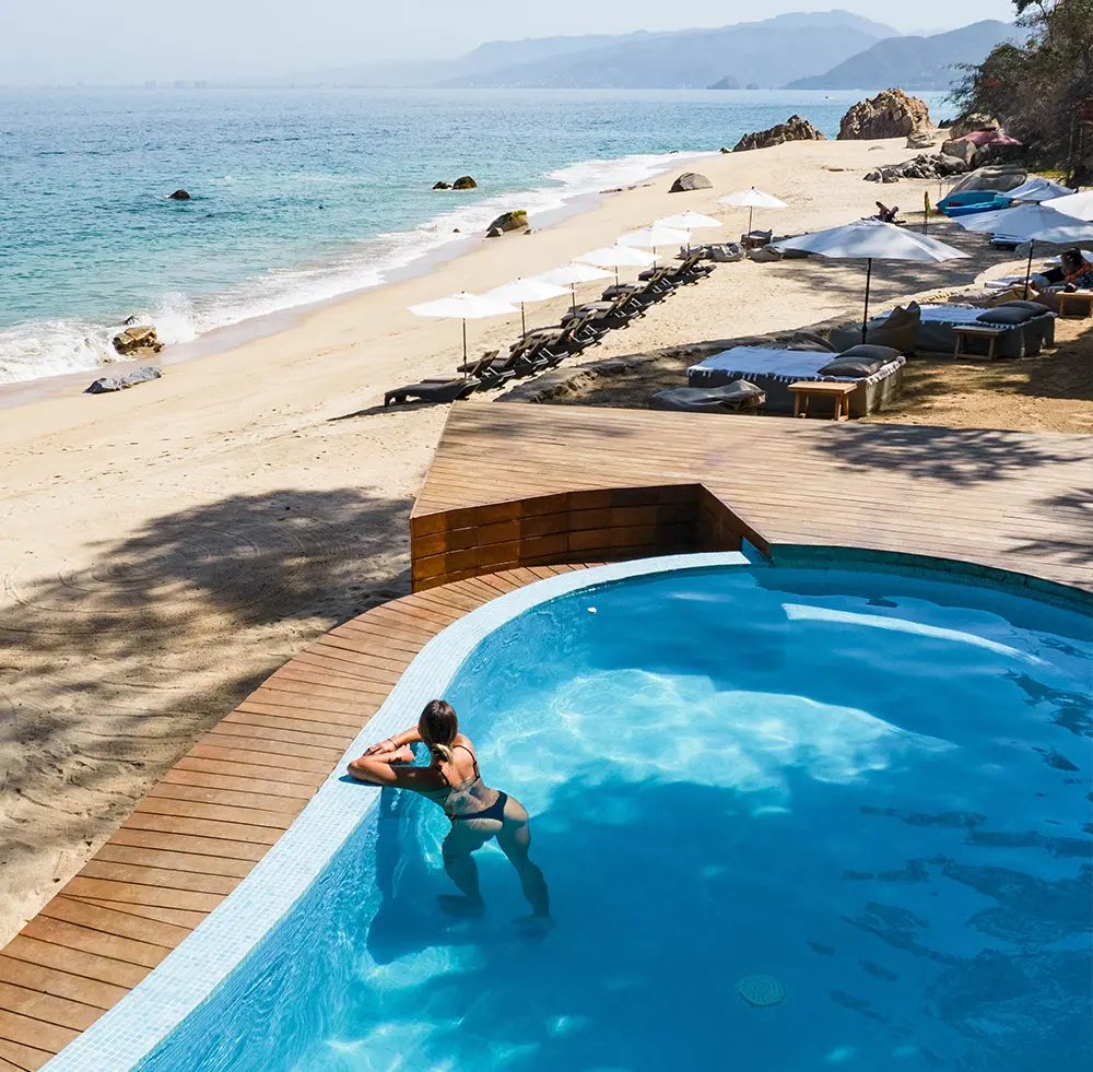 Huésped refrescandose en la piscina y admirando el paisaje en Xinalani