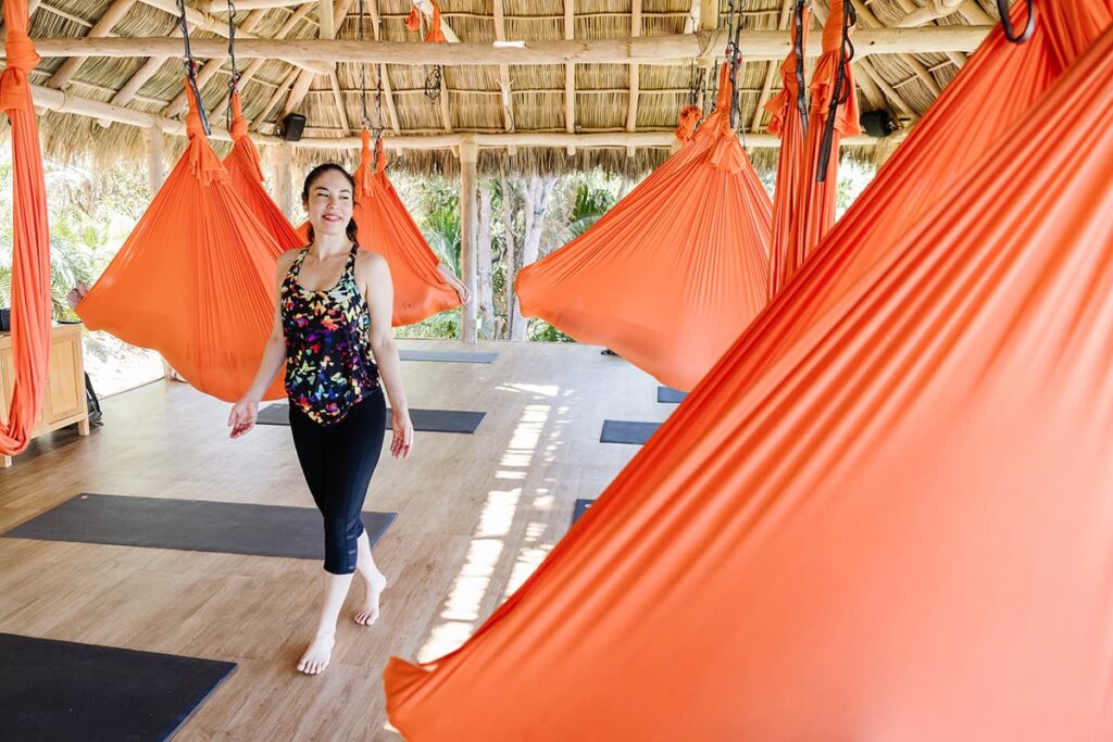 Sophia Mallie, an aerial yoga instructor, walks among her students floating in their aerial yoga hammocks in Xinalani.